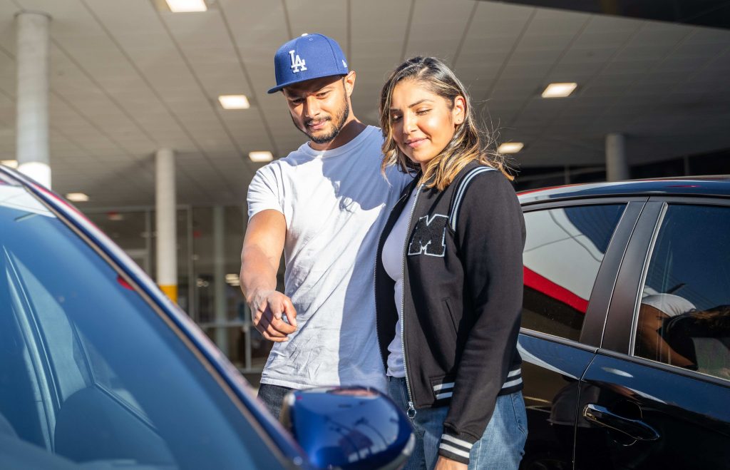 Phtoto of a couple Buying a car in a used car dealership