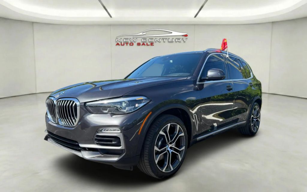 Dark grey BMW X5 SUV parked at New Century Auto Sale showroom