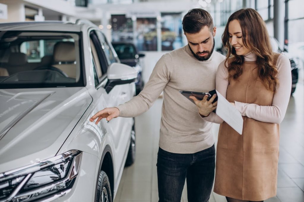 Saleswoman talking to a customer in a car dealership
