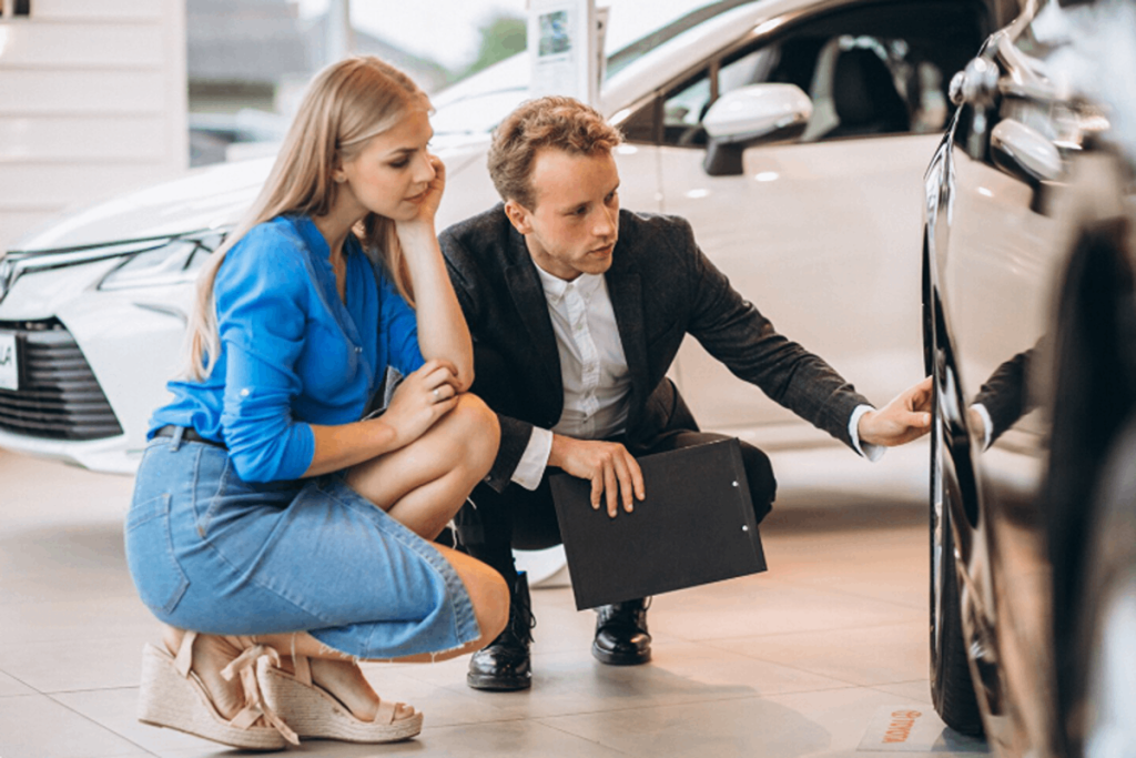 A car salesman showing off a car for sale