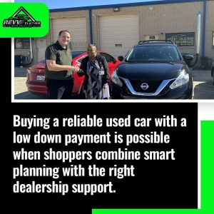 Buying a reliable used car with a low down payment is possible with REVV-elation Auto Sales LLC. Customer and salesperson shaking hands in front of cars.