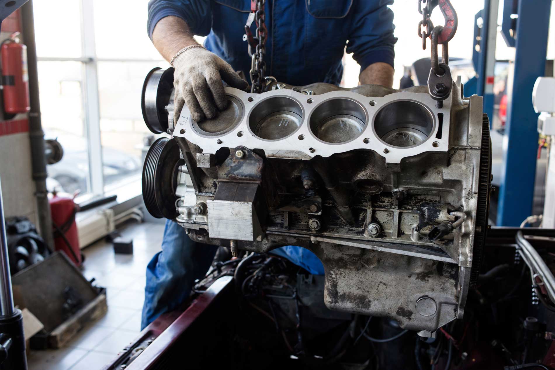 engine-repair2-681cc62e1ed2c Engine rebuilding service with technician handling car engine block at Qwest Automotive Service Las Vegas NV