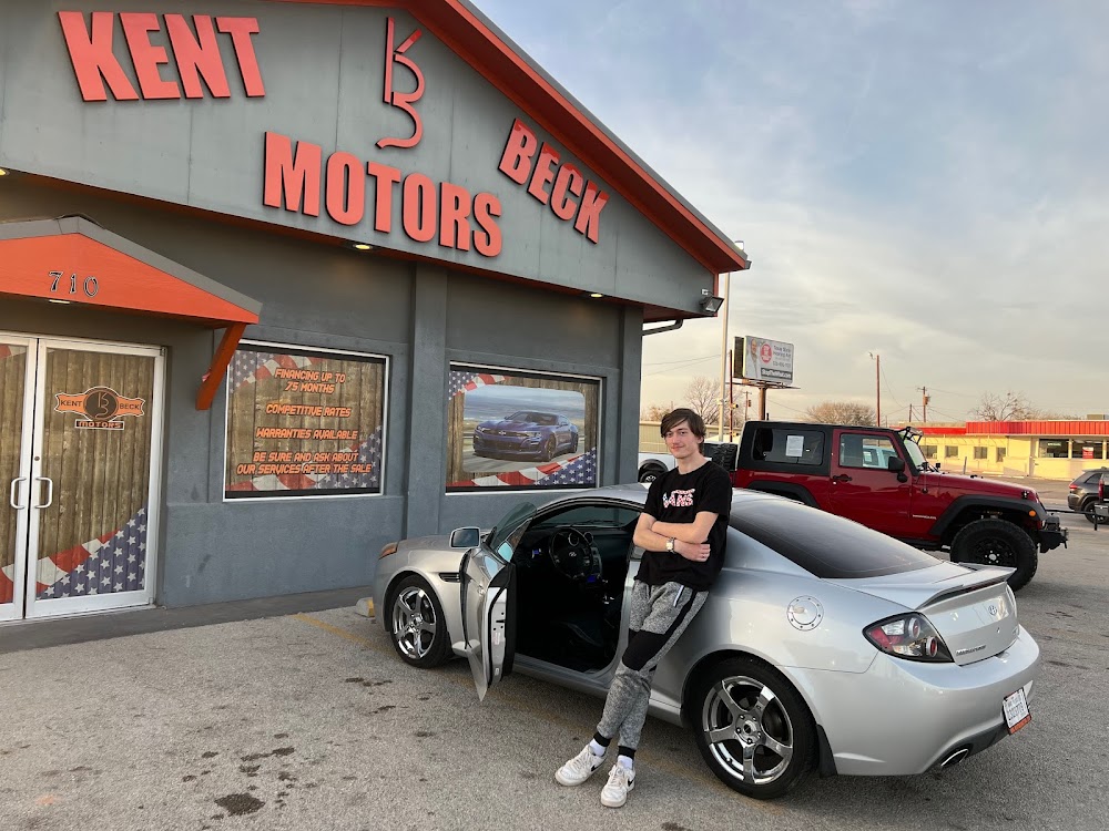 A happy customer sitting in front of his new car he bought from Kent Beck Motors a trustworthy used car dealership in Abilene, TX