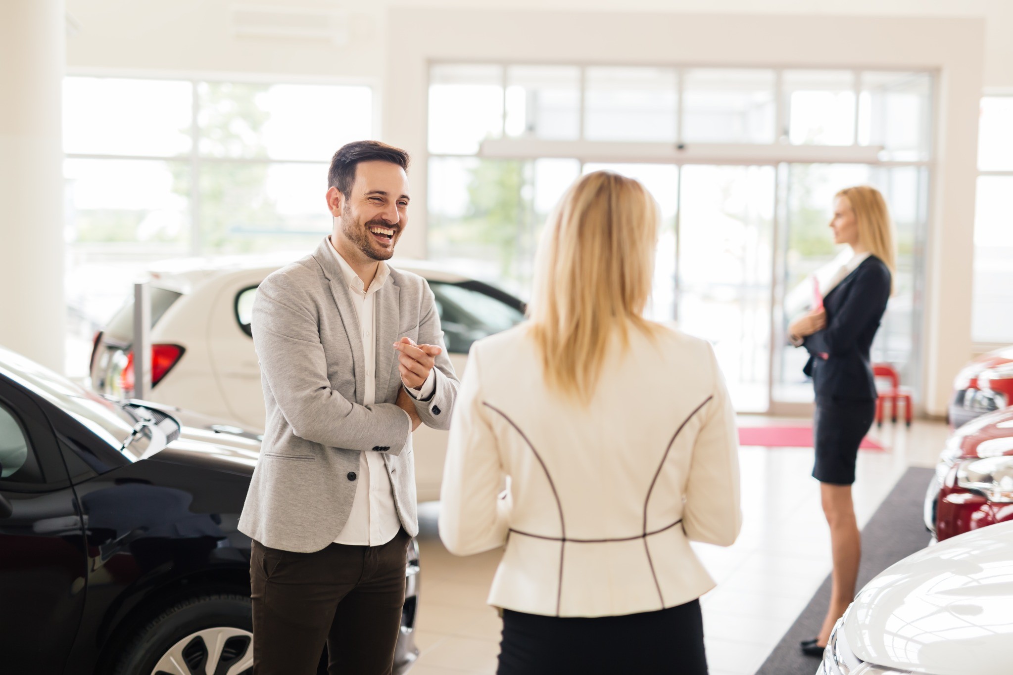 Salesperson speaking with a customer at a buy here pay here used car dealership