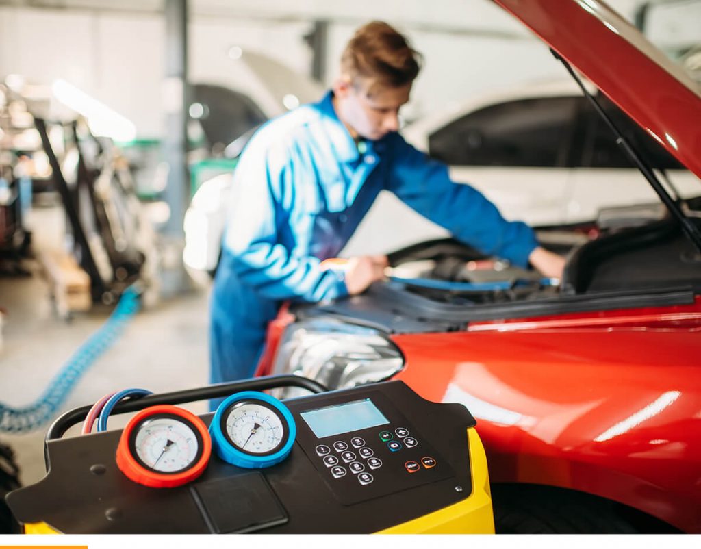 Car mechanic inspecting a red car.