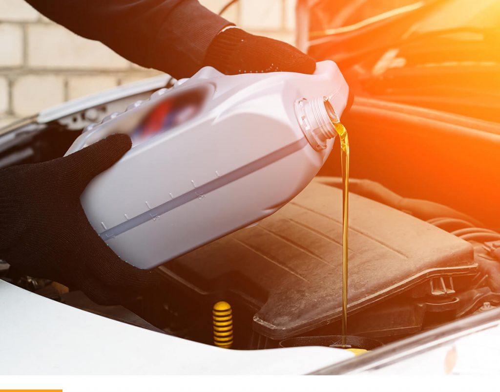 Person pouring oil into a car.