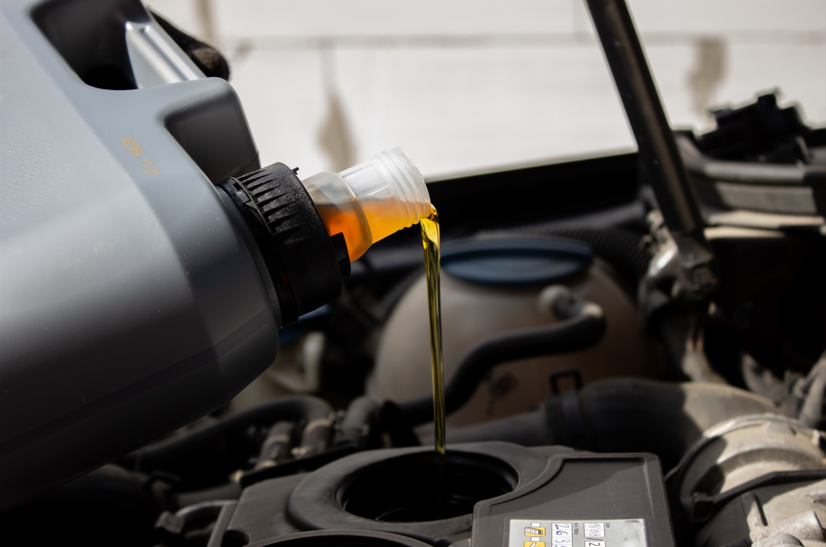 Engine oil being poured into a vehicle as part of a routine oil change.