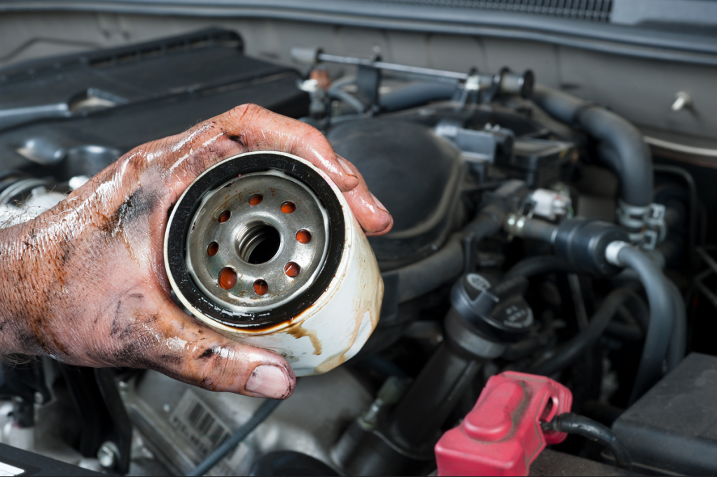 Mechanic holding dirty oil filter.