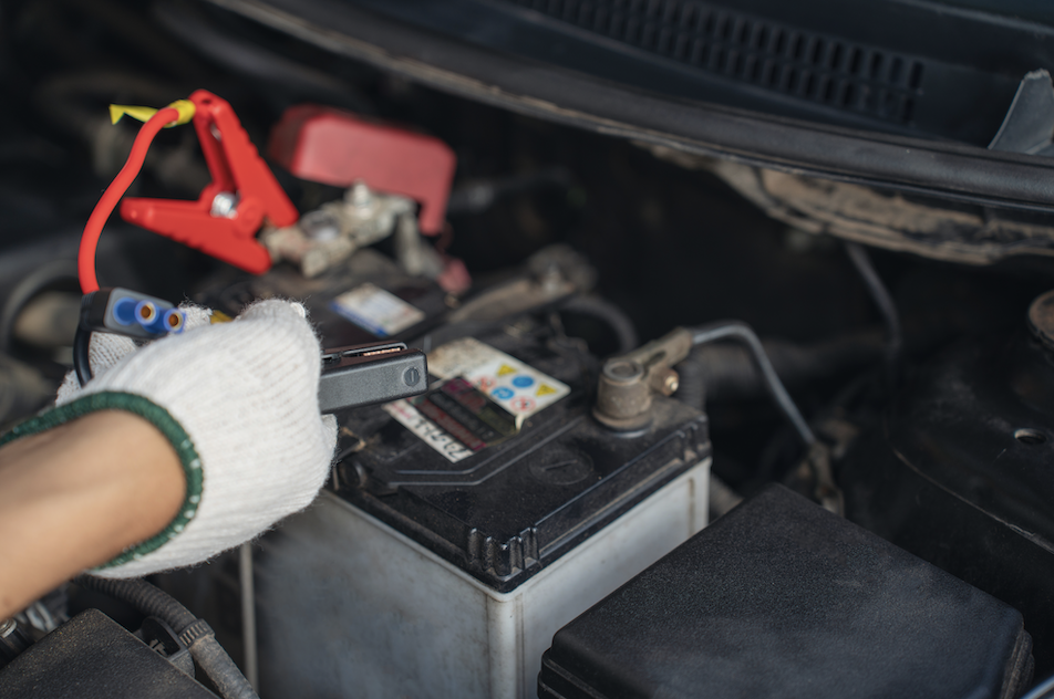 technician testing batteries with volt meter.