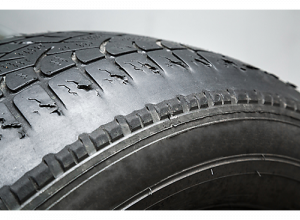 tire worn on one side due to wheel misalignment.