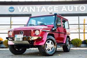 Front three-quarter view of a metallic red Mercedes G-Wagon
