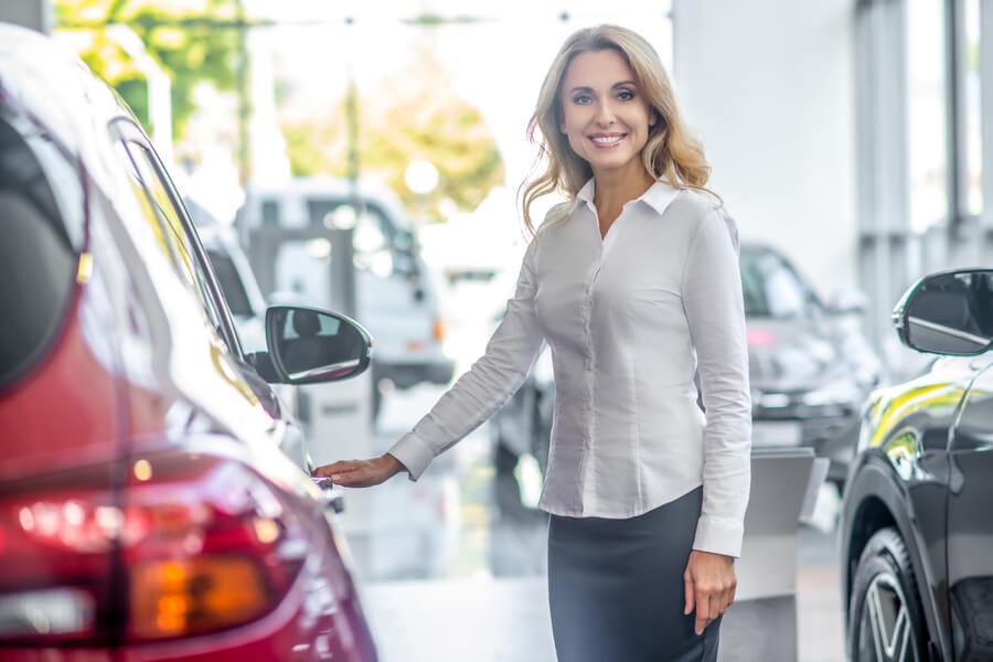Car dealer miami - Woman holding car keys at dealership