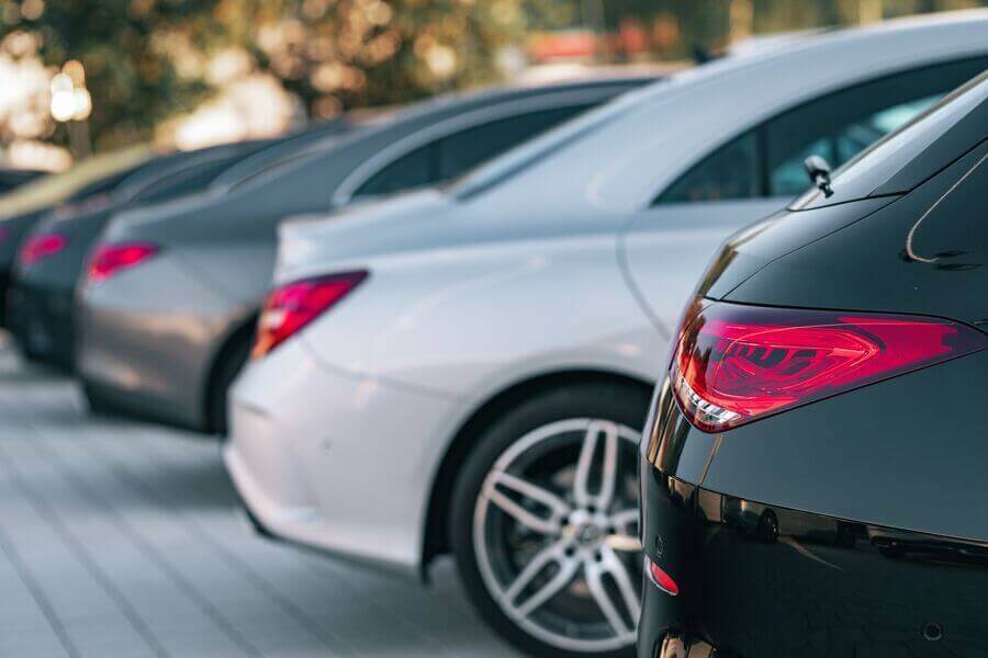 Miami dealer used cars - Row of parked cars viewed from the rear.
