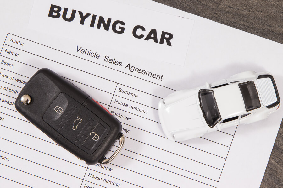 Income tax refund - Car purchase agreement with keys and a toy car.