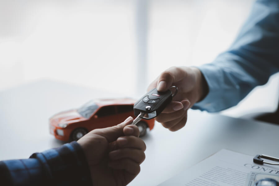 Income taxes receivable - Hands exchanging car keys over a contract.