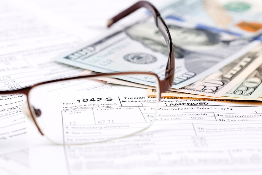 Income taxes receivable - Tax form with cash and eyeglasses.