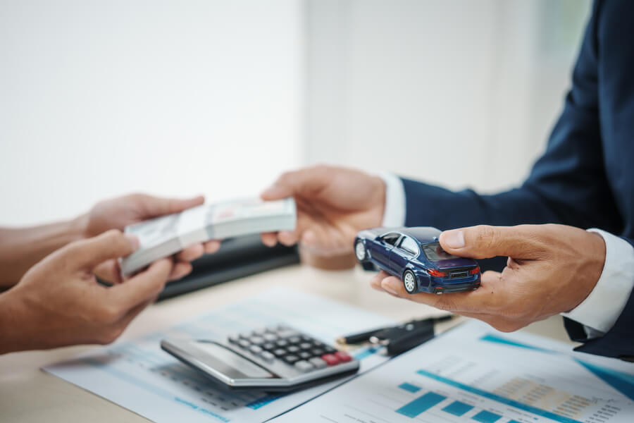 Income taxes receivable - Hands exchanging a credit card over documents and a calculator.