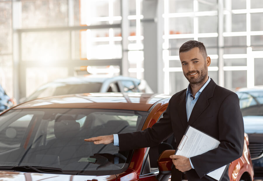 Sales consultant presenting a car inside a dealership showroom