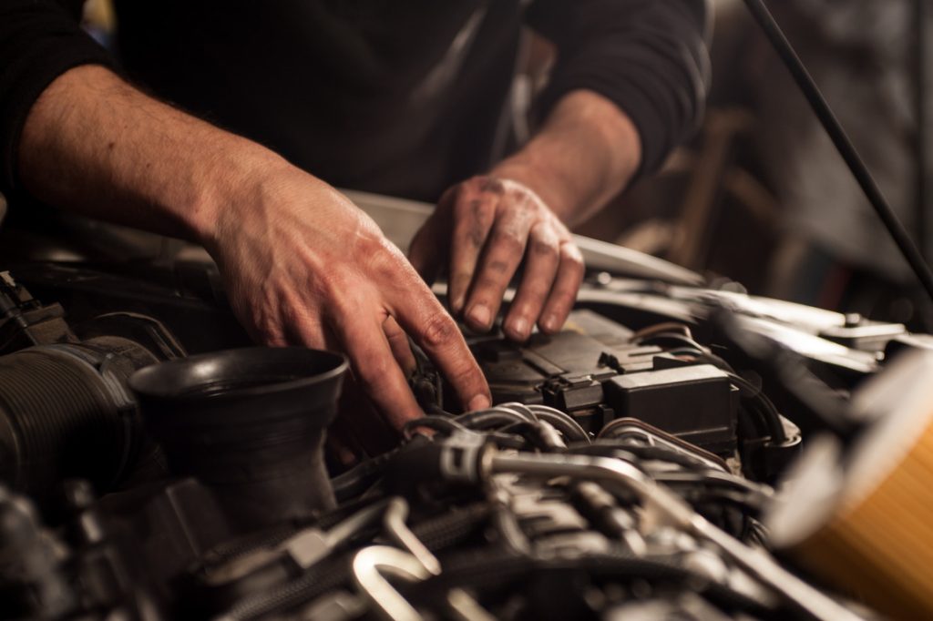 Mechanic’s hands performing detailed engine work at 916 Auto Mart’s on-site service department, ensuring thorough servicing and maintenance of used cars