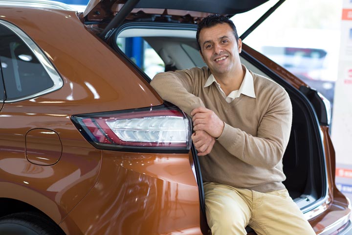 A Hispanic mature man purchasing a car at Auto Moto Deals