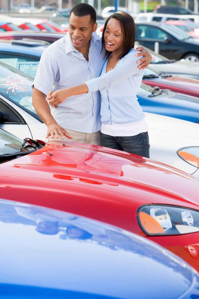 Excited young couple exploring a wide selection of vehicles at Auto Moto Deals dealership