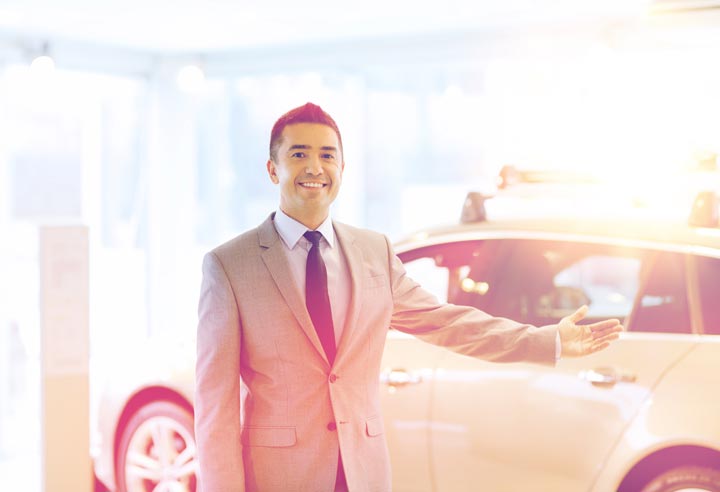 A friendly salesman welcoming customers at the Auto Moto Deals car dealership