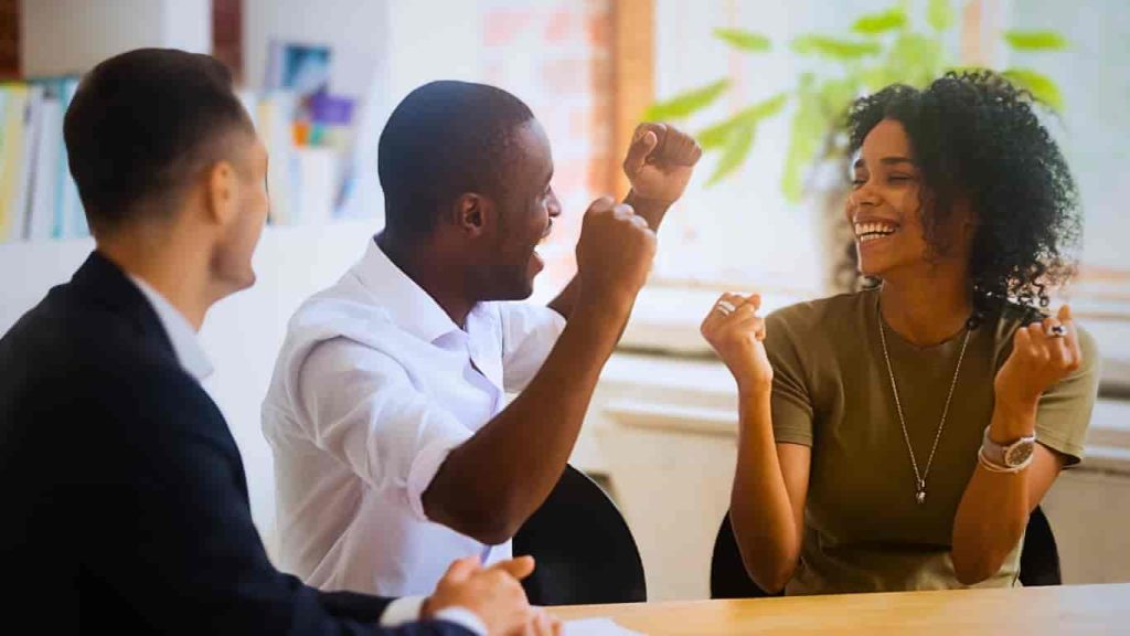 happy couple cheering over the good news of achieving in house financing customer success 