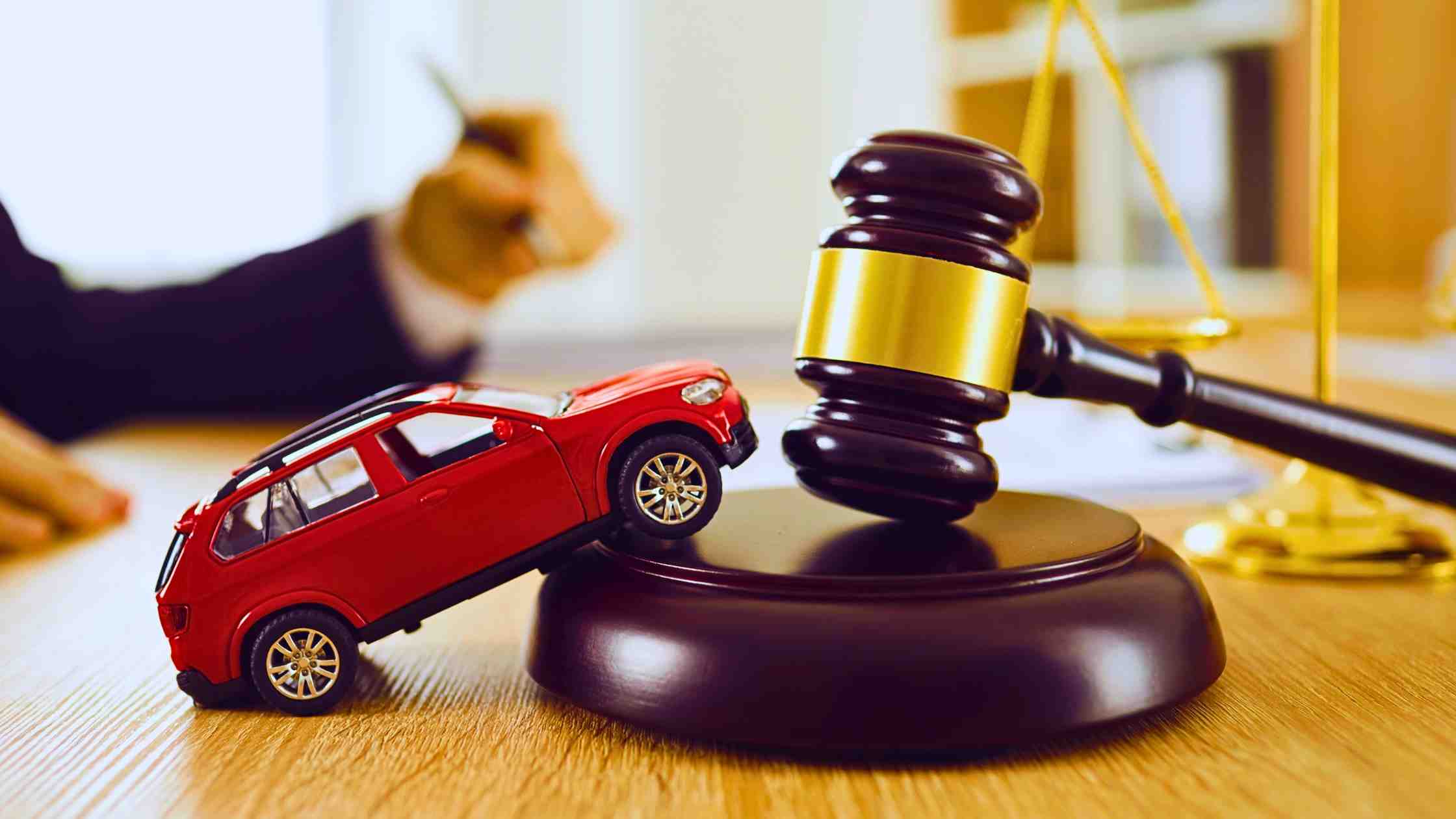 a toy car on top of an auction mallet depicting car auctions