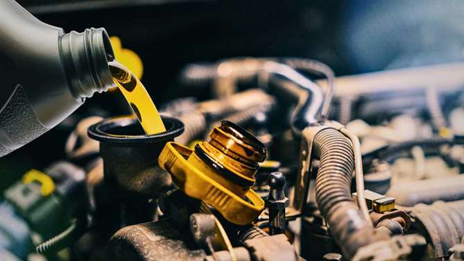 a used car engine having fresh oil poured into it during an oil change