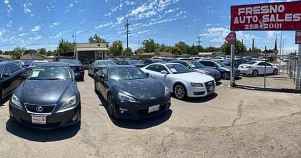a row of cars with a sign of Fresno Auto Sales