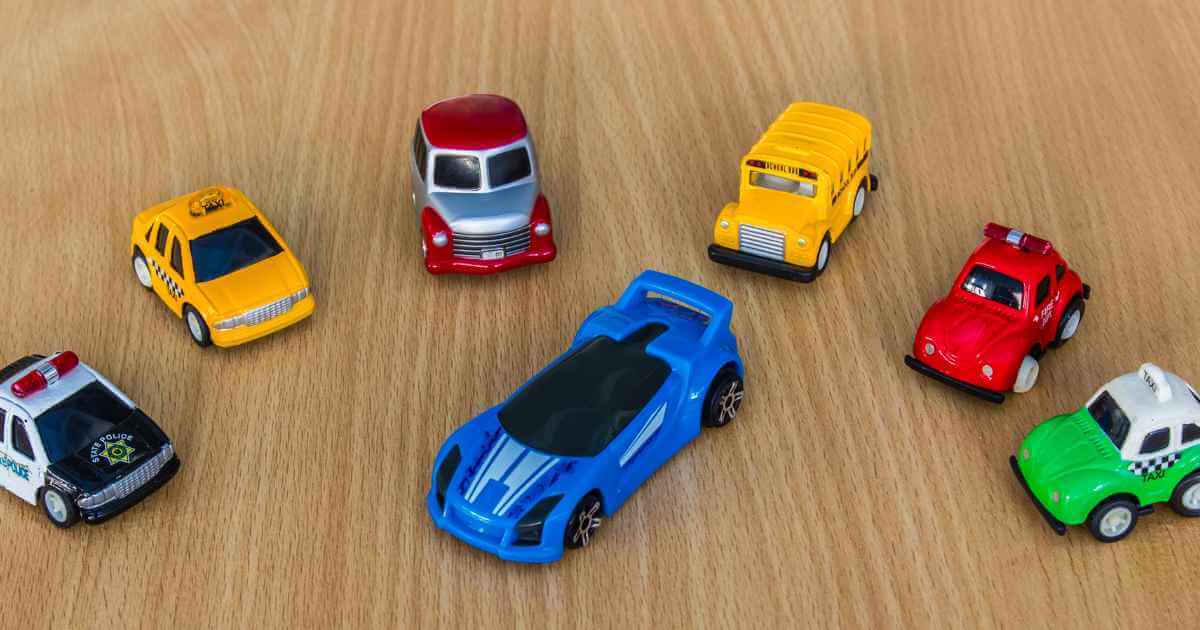 a group of toy cars surrounding a nicer and bigger toy car that is set apart like finance here car dealerships