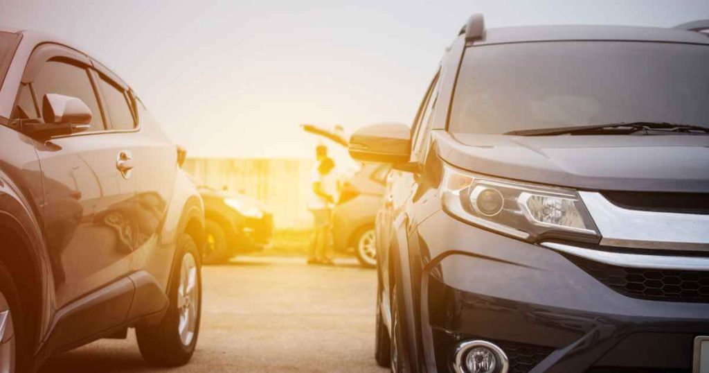 a photo of two used cars with the sun setting behind them at a buy here pay here auto sales