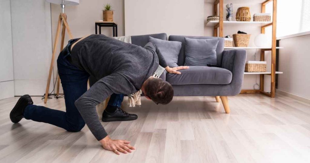 a man looking under the couch trying to find a cosigner for car loans