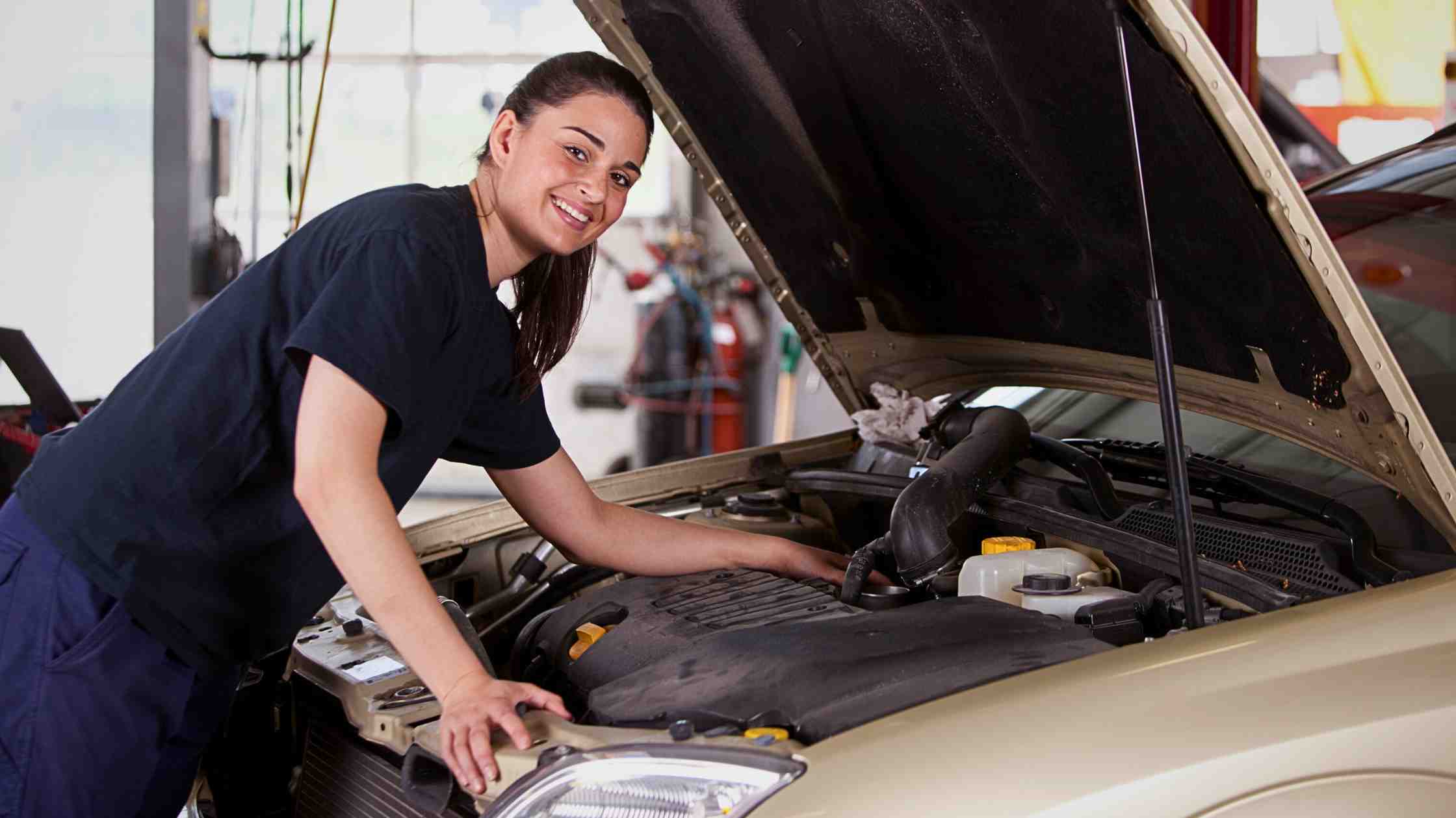 a woman under the hood inspecting used cars for sale