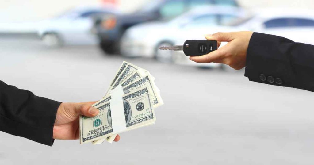 hands exchanging money for car keys showing you can trade in a car to make up a good down payment on a car