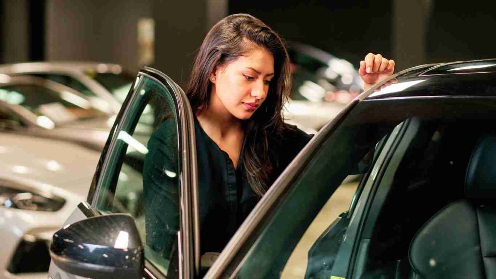 a picture of a woman looking into a car knowing what to look for in dealerships near me