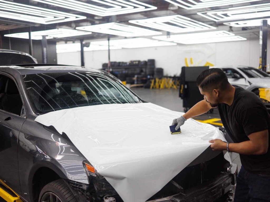 Westland auto sales a man who is specializing the paint on the hood of a car