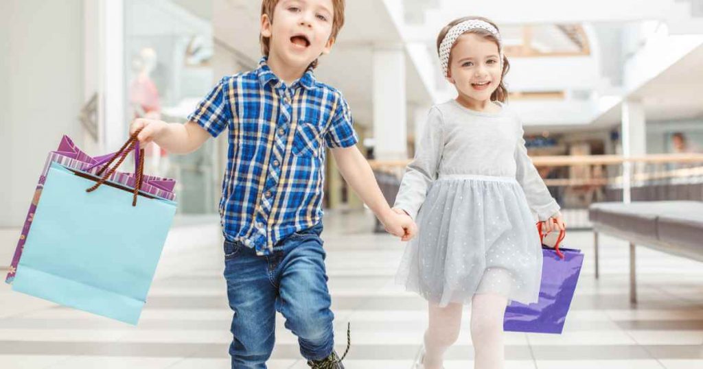 a little boy and girl running happy with shopping bags showing they just purchased at no credit car dealerships near me