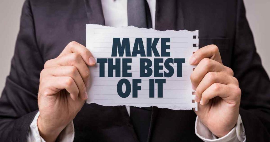 a man holding paper that reads "make the best of it"