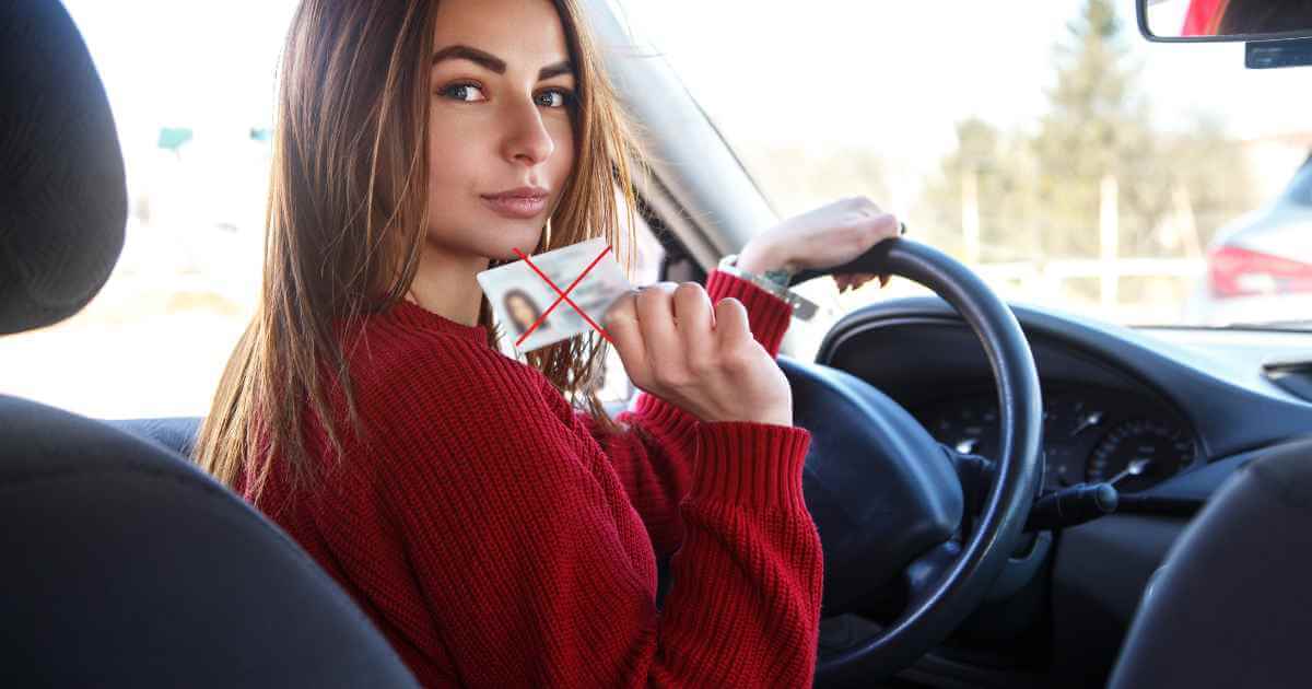 a woman about to drive a car showing a license with an X depicting she was able to buy a car at no license car lots near me