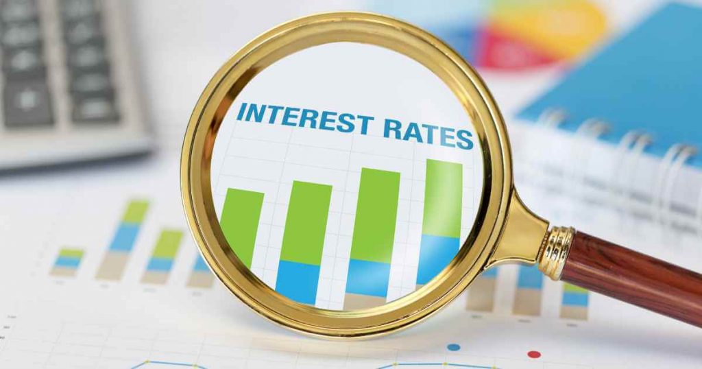 a magnifying glass zooming into the words "interest rates"