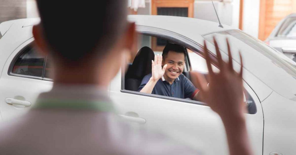 a man waving goodbye from inside a car showing the end of our article