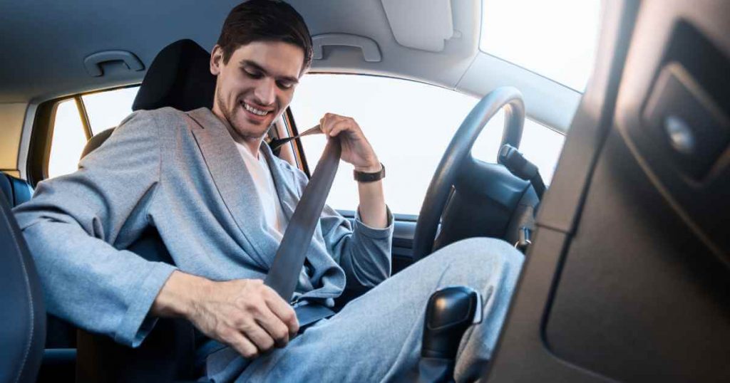 a man strapping in to his newly purchased used car after calculating interest on a car loan correctly