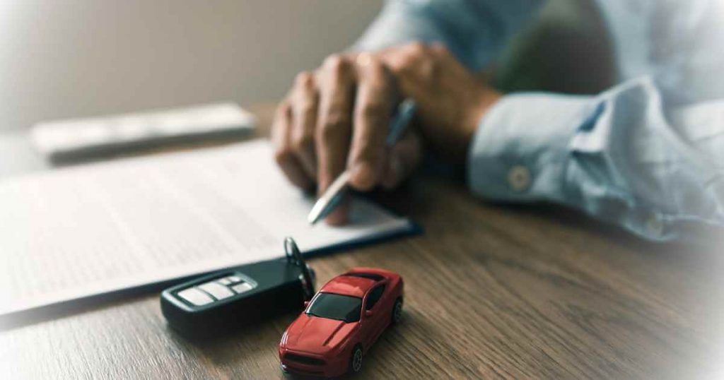 a man reviewing paperwork after learning how to buy a used car from a dealer