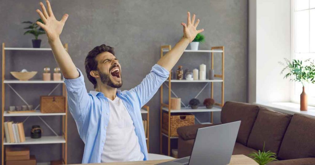 a man with his hands spread out wide and yelling loudly as he cheers