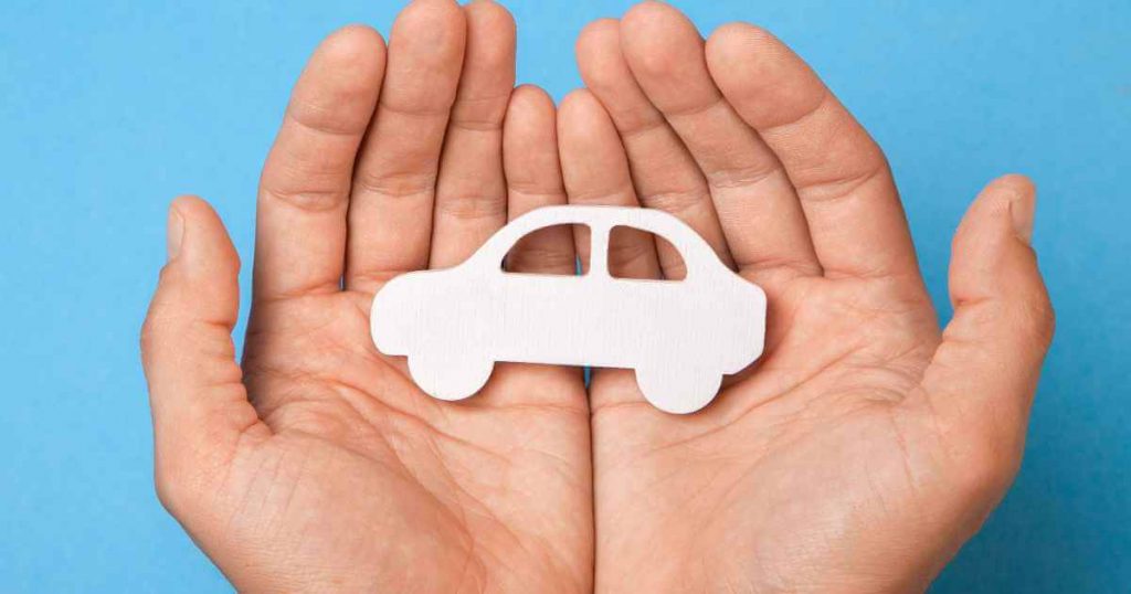 hands cupping a car cutout referring to cars plus credit vehicles