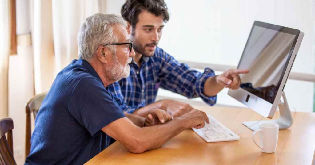 an older man and a younger one showing him how to use a car depreciation calculator