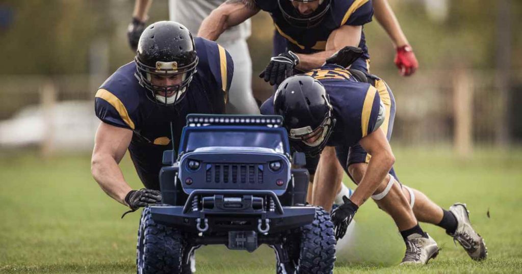 football players tackling a truck as they try to find out do you need credit to buy a car