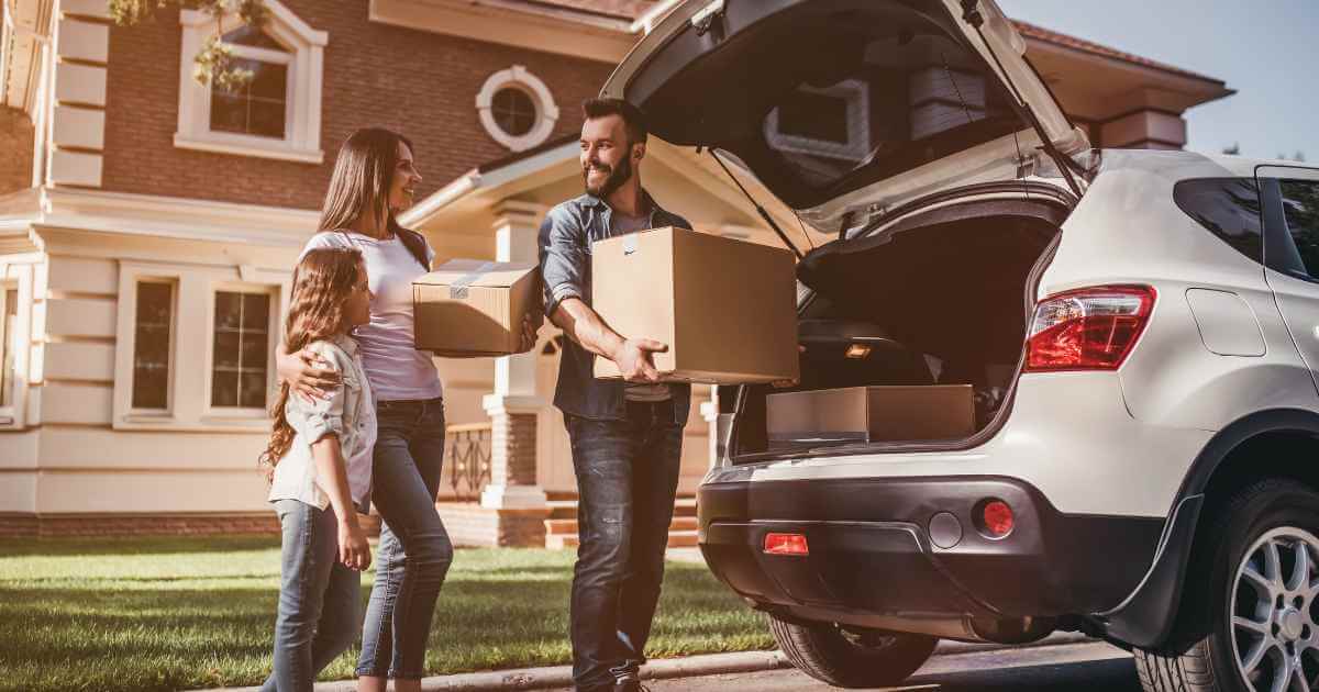 a family unloading groceries after purchasing their car with in house financing