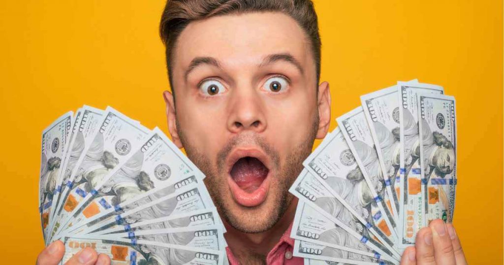 a man with money bills in awe as he triumphs over low down payment no credit check car deals